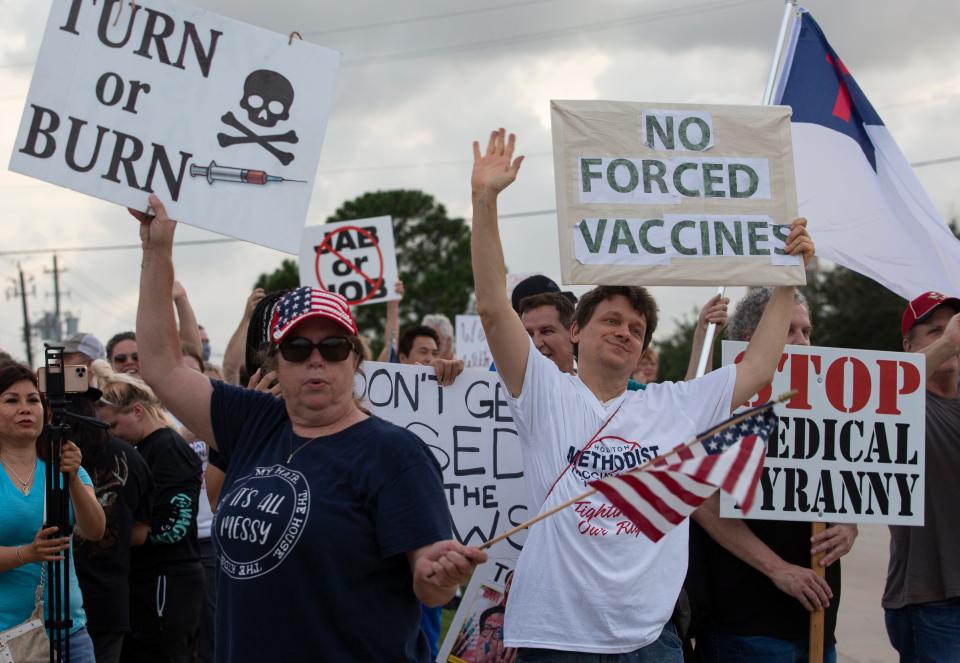 Protesters wave signs at Houston Methodist Baytown Hospital in Baytown, Texas, on Monday, June 7, 2021.