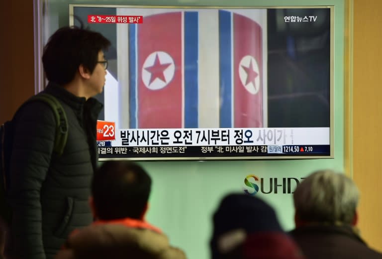 People watch a news report on North Korea's planned rocket launch as the TV shows file footage of North Korea's Unha-3 rocket which launched in 2012, at a railway station in Seoul on February 3, 2016