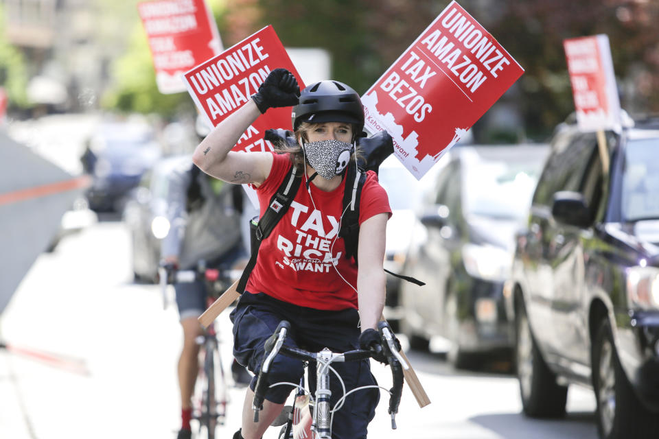 Protesters cycle around the block as they participate in a "car caravan" protest at the Amazon Spheres to demand the Seattle City Council tax the city's largest businesses in Seattle, Washington on May 1, 2020. - U.S. employees of Amazon, its supermarket subsidiary Whole Foods and supermarket delivery services were called to strike on May 1, taking advantage of May 1 to denounce employers accused of not sufficiently protecting them in the face of the pandemic. (Photo by Jason Redmond / AFP) (Photo by JASON REDMOND/AFP via Getty Images)