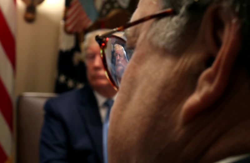 FILE PHOTO: U.S. President Donald Trump is seen through the glasses of U.S. Attorney General William Barr during a cabinet meeting at the White House in Washington