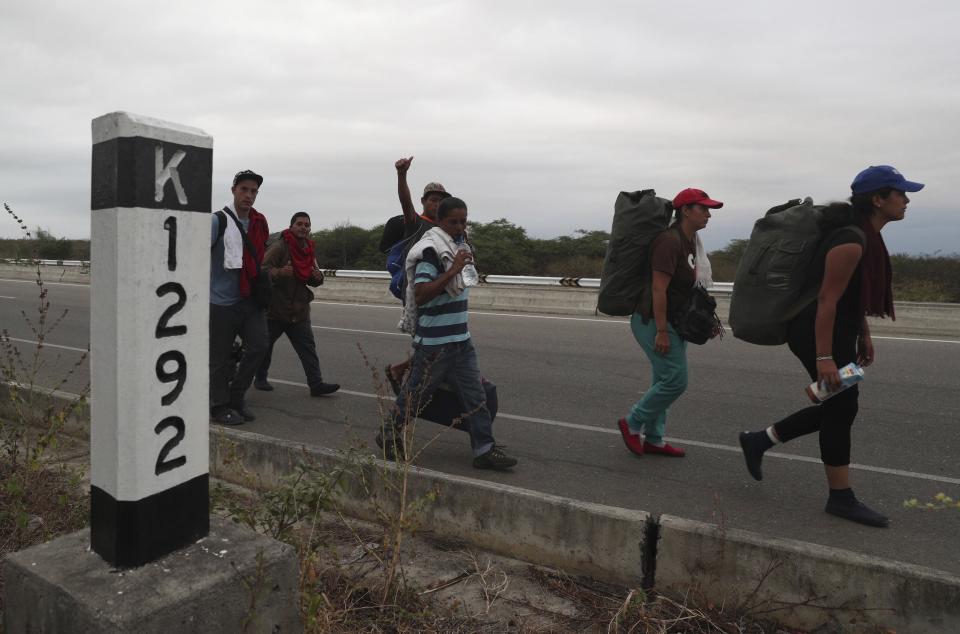 Venezuelan migrants walk on the Pan-American Highway, after crossing the border Peru - Ecuador border, in Tumbes, Peru, Friday, June 14, 2019. Venezuelan citizens are rushing to enter Peru before the implementation of new entry requirements on migrants fleeing the crisis-wracked South American nation. (AP Photo/Martin Mejia)