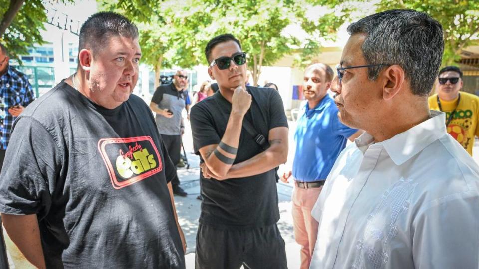 El presidente de Fresno Street Eats, Mike Osegueda, a la izquierda, habla con el concejal de Fresno Miguel Arias después de que Arias anunciara una pausa forzada por la ciudad en la operación de vendedores al aire libre en el ArtHop del 1 de agosto, durante una conferencia de prensa en Kern Plaza en el centro de Fresno, el viernes 19 de julio de 2024.