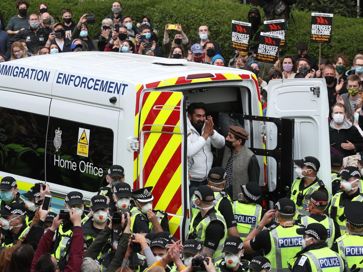 <p>One of the two detained men thanks crowds as he is freed from the immigration van in Kenmure Street, Glasgow, on Thursday</p> (PA)