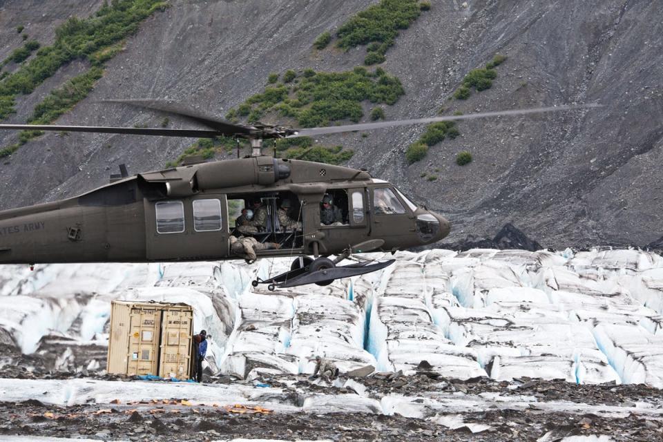 A UH-60 Blackhawk helicopter from the Alaska Army National Guard prepares to drop off members of the 3rd Aircraft Maintenance Squadron's Crash Recover team on Colony Glacier, Alaska July 10, 2012. The recovery team responded to a sighting by the National Guard that appeared to be an aircraft wreckage.