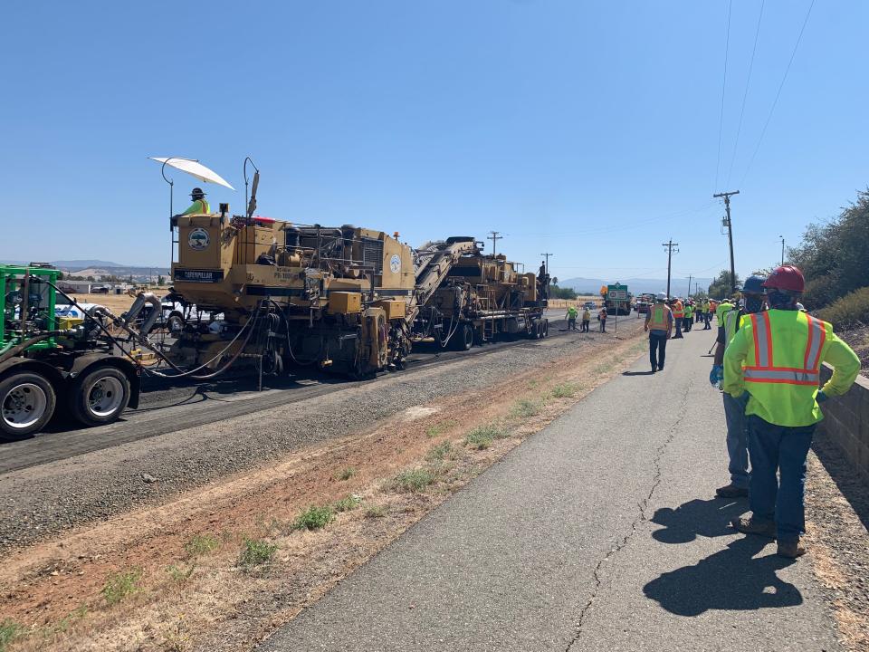 The "recycling train'' scoops up the old asphalt, grinds it, blends it with a binder and lays it down to form the new pavement.