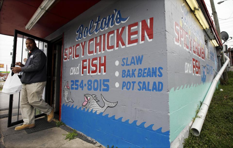 In this Friday, March 22, 2013, photo, a customer carries out an order from Bolton's Spicy Chicken and Fish restaurant in Nashville, Tenn. Hot chicken -- fried chicken with varied amounts of seasoning that make the heat level run from mild to extra hot -- is a signature dish of Nashville. (AP Photo/Mark Humphrey)