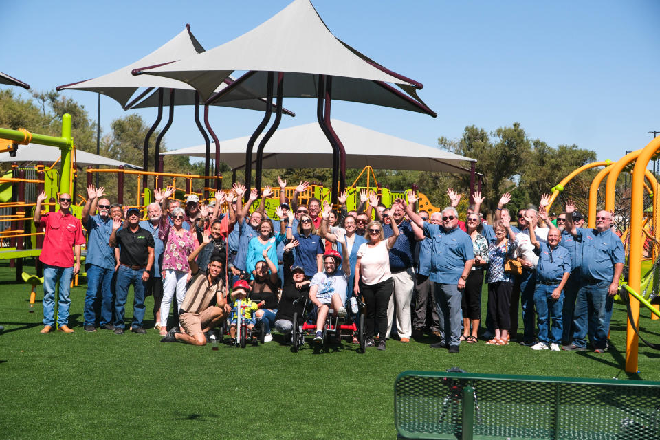 Members of AMBUCS and friends stand on the playground of the newly built Kylie Hiner Memorial Park Thursday in Canyon.