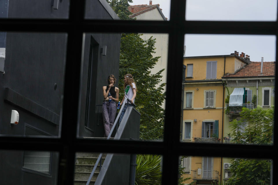 Models relax outside the backstage of the N21 women's Spring Summer 2024 collection presented in Milan, Italy, Wednesday, Sept. 20, 2023. (AP Photo/Luca Bruno)