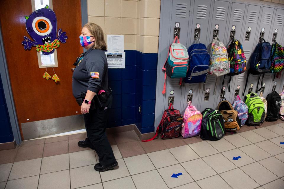 School Resource Officer Deputy Angela Young walks past a wall of lockers in Pine Level Elementary School on March 4, 2021.