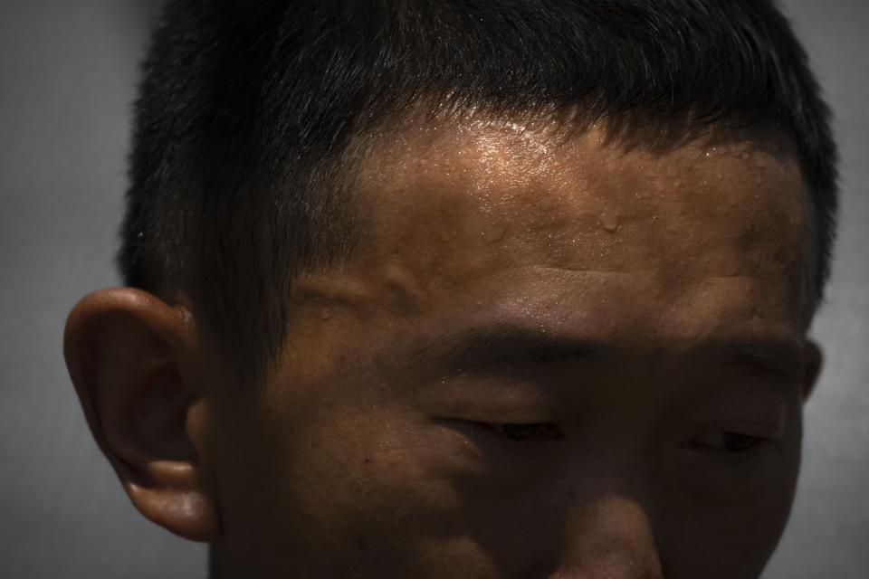 FILE - Sweat forms on the forehead of Gan Bingdong as he stands amid vegetable plots on a hot day at his farm in Longquan village in southwestern China's Chongqing Municipality, Aug. 20, 2022. Earth’s fever persisted last year, not quite spiking to a record high but still in the top five or six warmest on record, government agencies reported Thursday, Jan. 12, 2023. (AP Photo/Mark Schiefelbein, File)