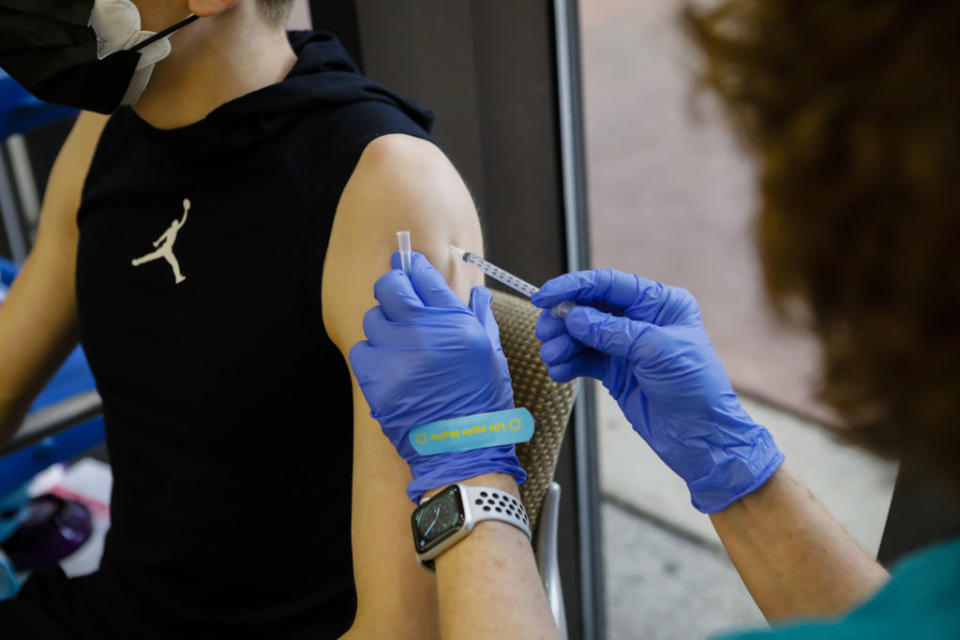 A healthcare worker administers a dose of the Pfizer to a teenager in the US earlier this week. Source: Getty