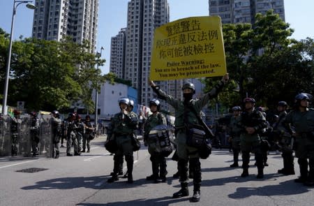 Riot police hold a sign during an anti-government march in Tuen Mun, Hong Kong
