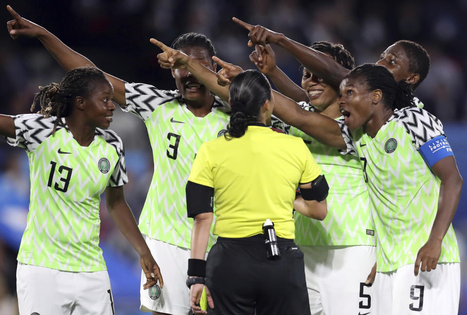 Nigeria players points towards the electronic screen as they protest a yellow card and a penalty awarded against their goalkeeper Chiamaka Nnadozie by Melissa Borjas of Honduras, middle, during the Women's World Cup Group A soccer match between Nigeria and France at the Roazhon Park in Rennes, France, Monday, June 17, 2019. (AP Photo/Vincent Michel)