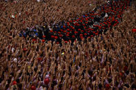 FILE - Revellers raise their arms as a band plays in the town hall square, while waiting for the launch of the 'Chupinazo' rocket, to mark the official opening of the 2022 San Fermin fiestas in Pamplona, Spain, Wednesday, July 6, 2022. Before the pandemic, the festival was last suspended in the Spanish Civil War in the 1930s. (AP Photo/Alvaro Barrientos, File)