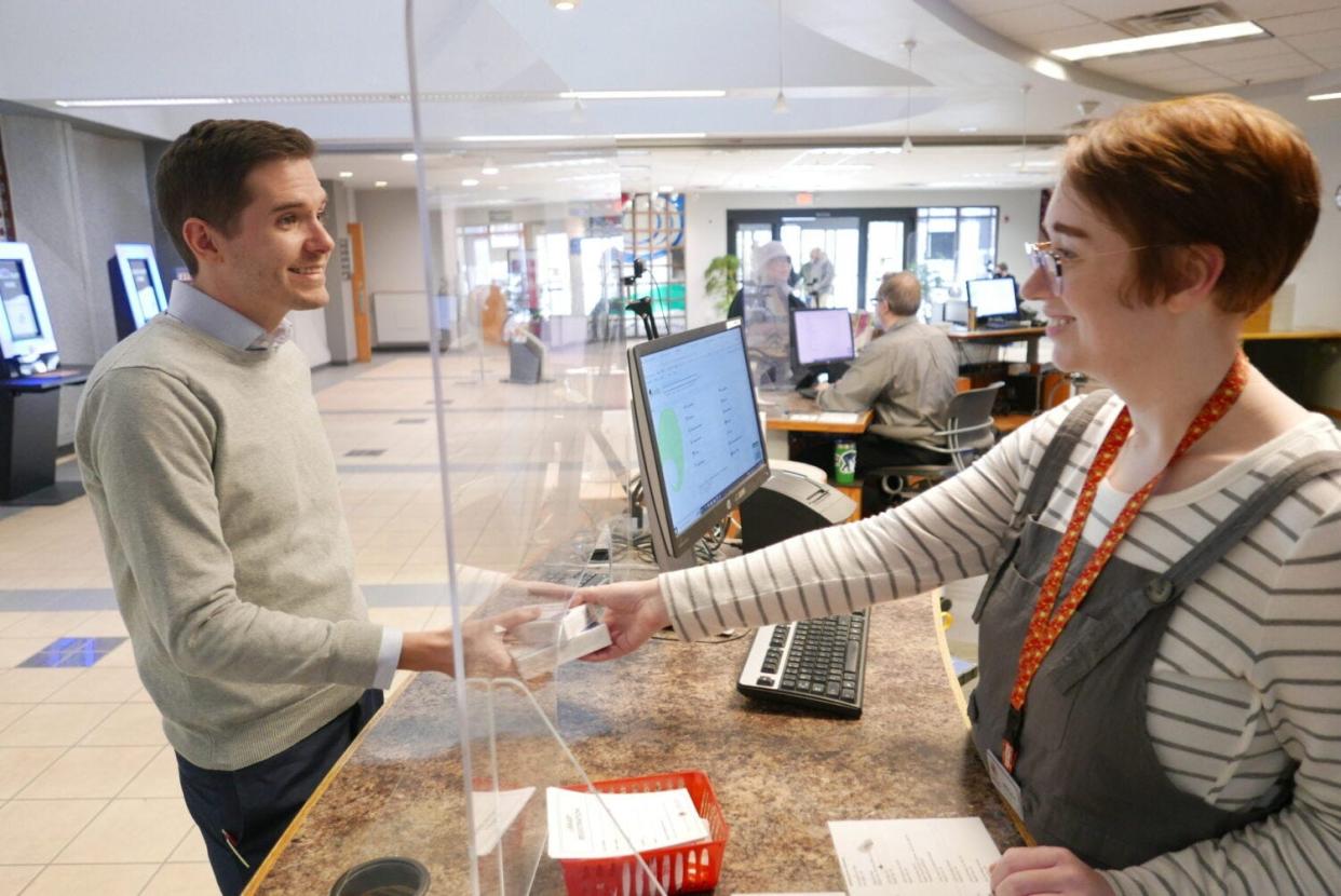 An employee of the Rapid City Public Library hands out free COVID-19 tests.