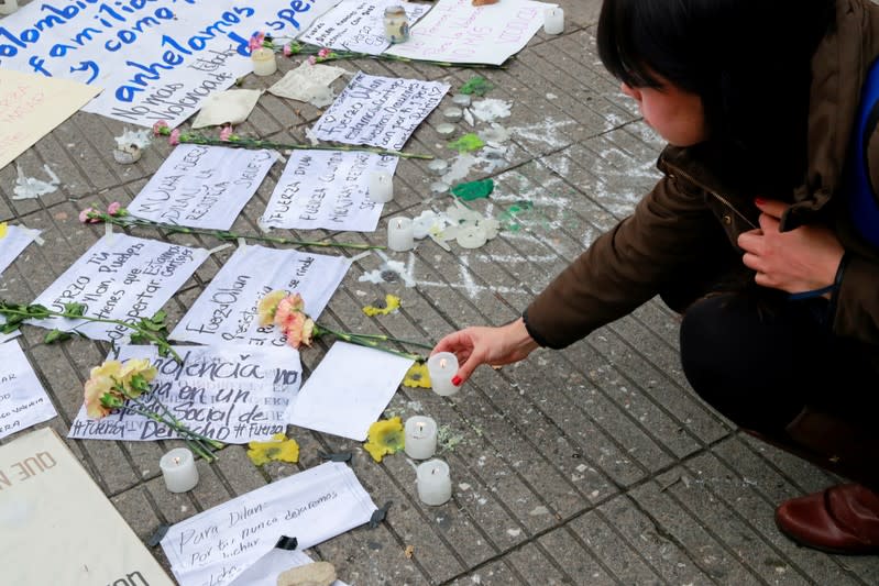 A person places a candle to honour Dilan Cruz, a teenage demonstrator who died after being injured by a tear gas canister during an initial strike last week, in Bogota