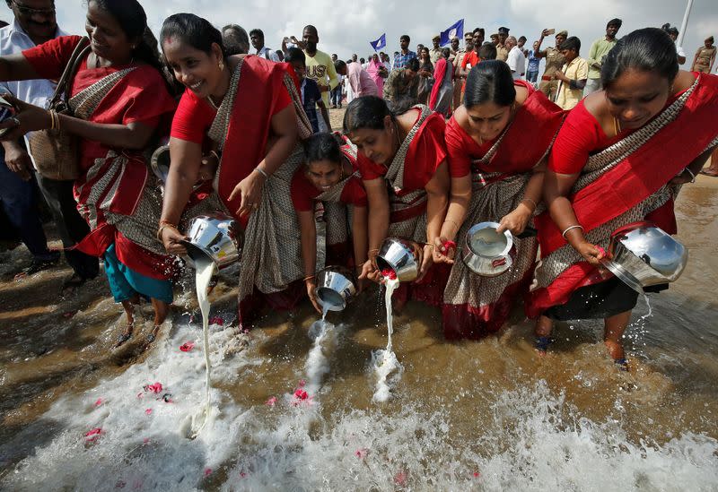 Women pour milk into the waters of the Bay of Bengal during a prayer ceremony for the victims of the 2004 tsunami on the 15th anniversary of the disaster, in Chennai