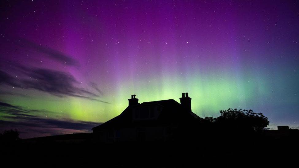 Aurora borealis and silhouette of a house in Orkney