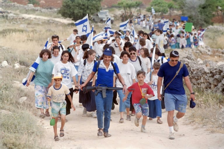 Unos colonos marchan para celebrar el 25º aniversario de la ocupación israelí de Hebrón, en Cisjordania, el 1 de junio de 1992 (Menahem Kahana)