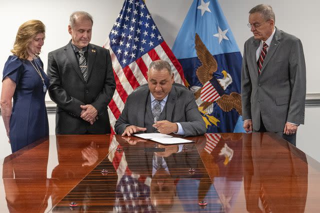 <p>Tech. Sgt. Jack Sanders / Department of Defense</p> On May 5 Department of Defense Under Secretary Gilbert Cisneros (seated) signed a policy to implement the Brandon Act.