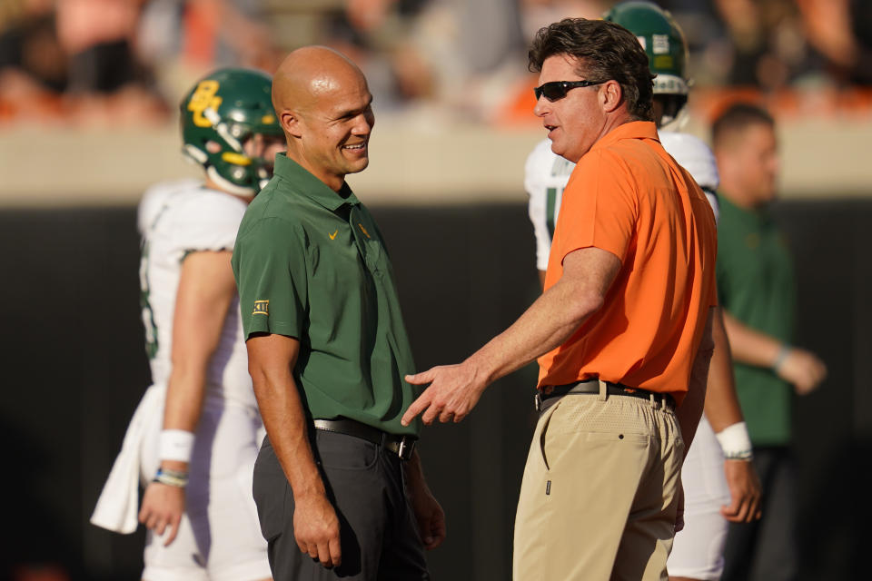 Baylor head coach Dave Aranda, left, and Oklahoma State head coach Mike Gundy talk before their NCAA college football game, Saturday, Oct. 2, 2021, in Stillwater, Okla. (AP Photo/Sue Ogrocki)