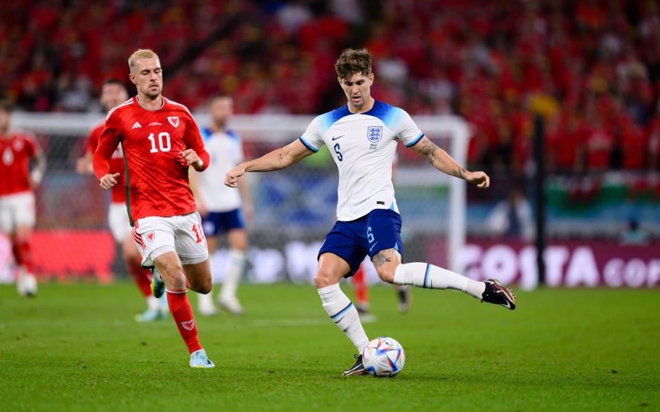 John Stones of England (R) battles for possession with Aaron Ramsey of Wales (L) during the FIFA World Cup Qatar 2022 Group B match between Wales and England at Ahmad Bin Ali Stadium on November 29, 2022 in Doha, Qatar - Markus Gilliar - GES Sportfoto/Getty Images