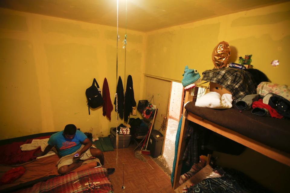 A migrant looks at his cellphone inside a bedroom at the Agape World Mission shelter used mostly by Mexican and Central American migrants who are applying for asylum in the U.S., on the border in Tijuana, Mexico, Monday, June 10, 2019. (AP Photo/Eduardo Verdugo)