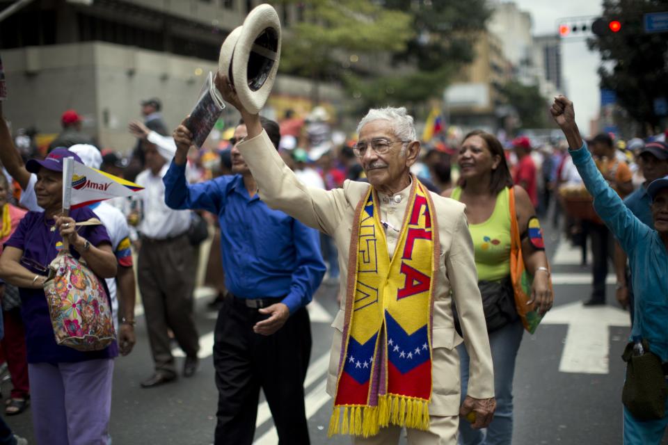 Pedro Pablo Rivero, 81, lifts his hat during a rally by elderly people in Caracas, Venezuela, Sunday, Feb. 23, 2014. The march was organized by the government in the name of peace, and ended at Miraflores presidential palace where the seniors met with Venezuela's President Nicolas Maduro. (AP Photo/Rodrigo Abd)