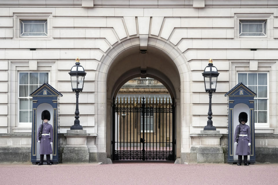 Two soldiers on guard outside Buckingham Palace one, of the official residences of King Charles III, in London, Tuesday, Feb. 6, 2024. Buckingham Palace says King Charles III has begun outpatient treatment for cancer, the statement issued Monday did not say what type of cancer he has. (AP Photo/Kin Cheung)