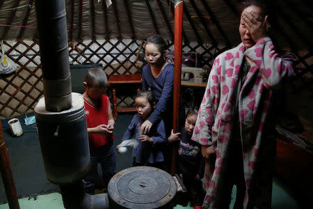 The wife and children of Setevdorj Myagmartsogt gather around their new coal burning stove while talking to reporters in their tent-like ger home in Ulaanbaatar, Mongolia January 29, 2017. Setevdorj Myagmartsogt, a part time worker at coal packing shop, lives with his wife, four kids and two relatives in their ger home near a coal depot not far from the city centre. REUTERS/B. Rentsendorj