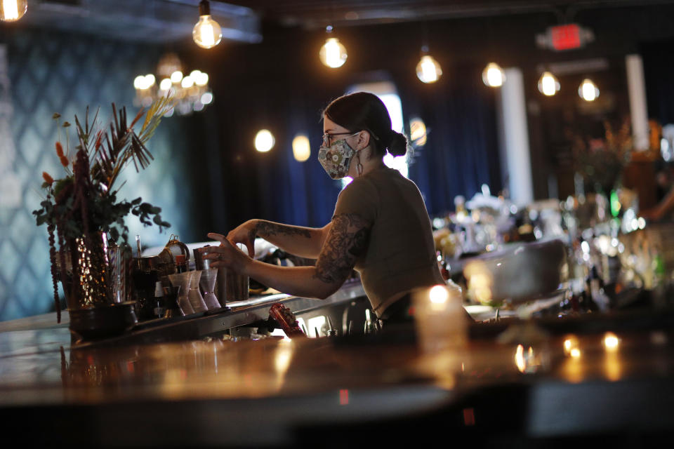 Alanna McDonnell mezcla bebidas en el Velveteen Rabbit, un bar en el Distrito Artístico de Las Vegas, en la última noche antes de que tengan que cerrar de nuevo el local ante un repunte de casos de coronavirus, el viernes 10 de julio de 2020, en Las Vegas. (AP Foto/John Locher)