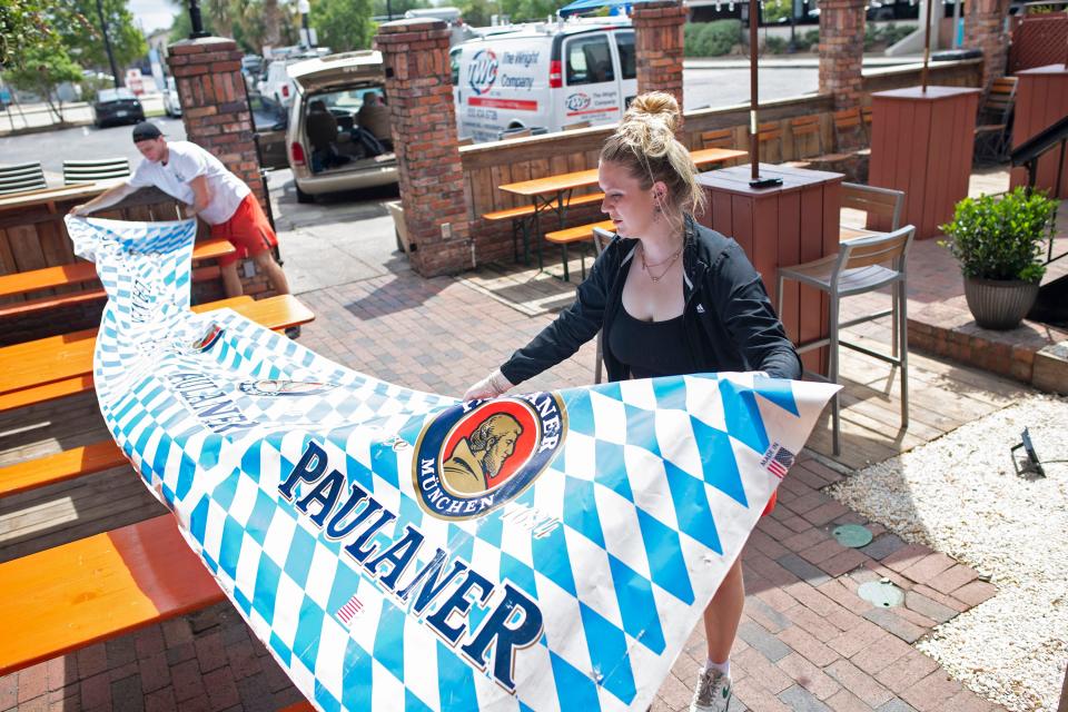 Colby LeSage and Ansley Denty put the finishing touches on the new beer garden at Bavaria Pensacola on Friday, April 21, 2023. 