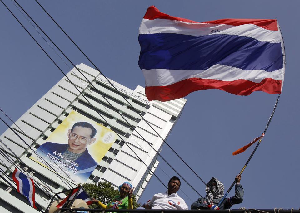 An anti-government protester waves a Thai national flag during a rally outside the Ministry of Natural Resources and Environment in Bangkok January 21, 2014. Some Thai rice farmers have threatened to switch sides and join protesters trying to topple the government if they do not get paid for their crop, a worrying development for Prime Minister Yingluck Shinawatra whose support is based on the rural vote. REUTERS/Chaiwat Subprasom (THAILAND - Tags: POLITICS CIVIL UNREST)