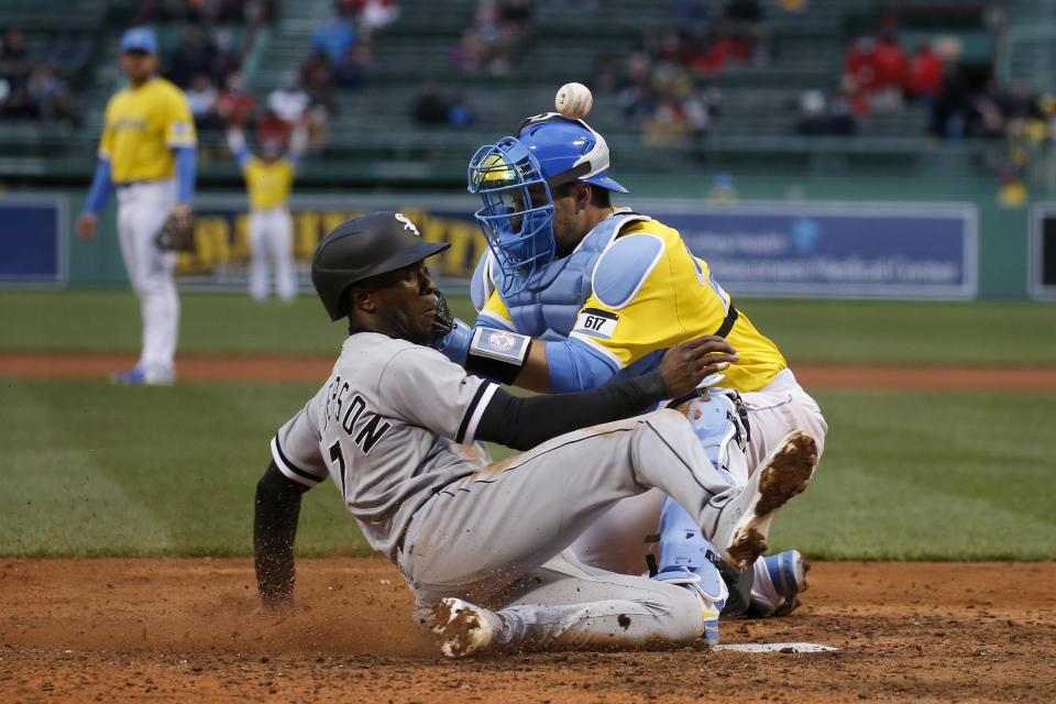 Boston Red Sox catcher Kevin Plawecki, right, cannot catch a throw from the outfield as Chicago White Sox's Tim Anderson slides in to score during the seventh inning of a baseball game, Saturday, April 17, 2021, in Boston. (AP Photo/Mary Schwalm)