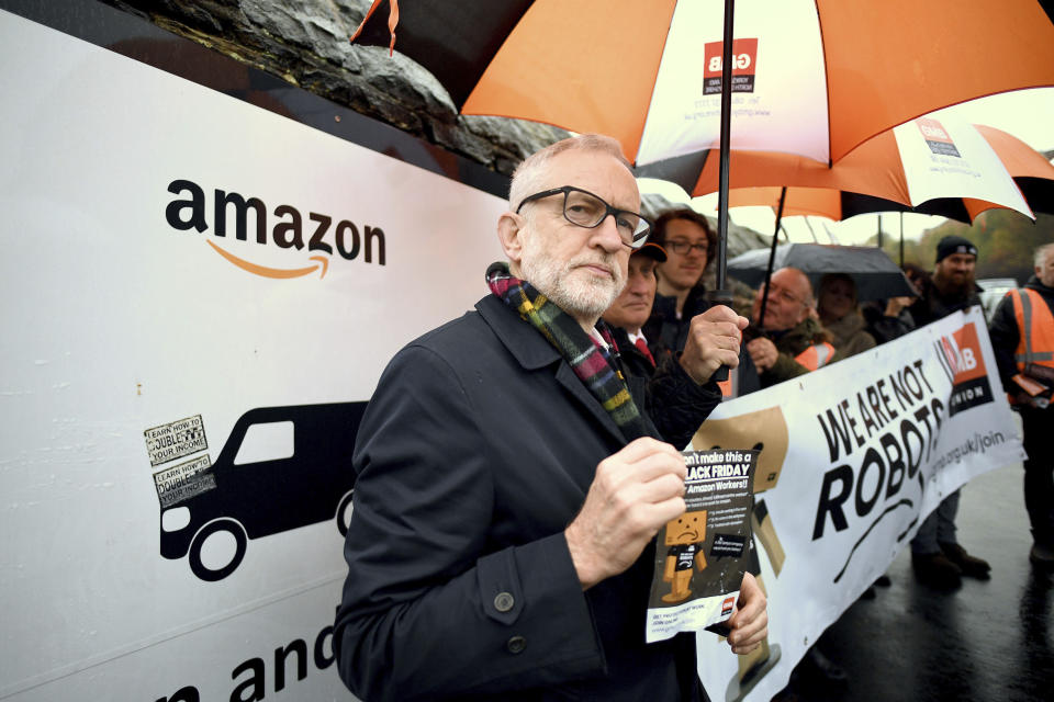 Labour Party leader Jeremy Corbyn stands outside an Amazon depot to announce plans for a workers' rights revolution and to ensure big businesses pay their fair share of taxes, in Sheffield, England, Saturday Nov. 23, 2019. Britain goes to the polls on Dec. 12. (Stefan Rousseau/PA via AP)