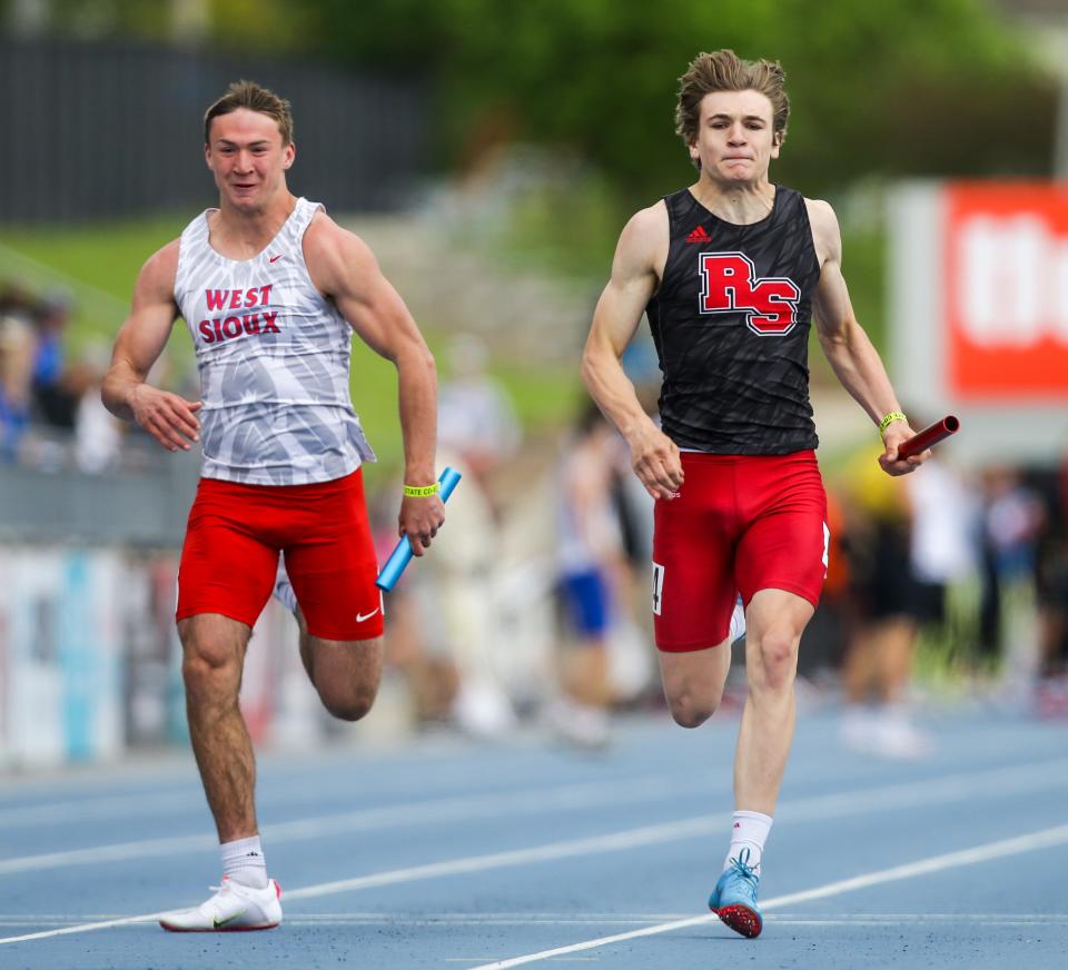 Roland-Story's Eli Thorson, right competes in the Class 2A 4x100 meter relay during the 2022 Iowa high school track and field state championships at Drake Stadium Saturday, May 21, 2022 in Des Moines.