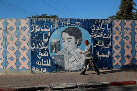 A man walks past a mural with writing in Arabic that reads, " My country, you gave us love and light which revealed paths for the lost" in the Israeli Arab city of Umm al-Fahm August 16, 2016. Picture taken August 16, 2016. REUTERS/Ammar Awad