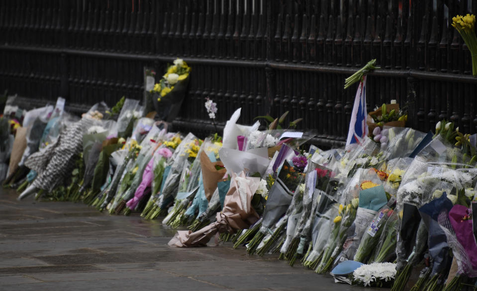 Flowers line the sidewalk in front of the gate outside Buckingham Palace in London, a day after the death of Britain's Prince Philip, Saturday, April 10, 2021. Britain's Prince Philip, the irascible and tough-minded husband of Queen Elizabeth II who spent more than seven decades supporting his wife in a role that mostly defined his life, died on Friday. (AP Photo/Alberto Pezzali)