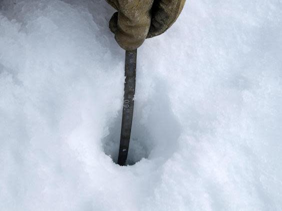 Researchers measure depths through an ice core hole (Bonnie Jo Mount)