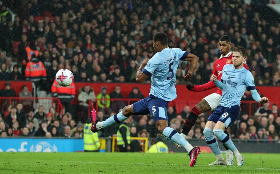 Marcus Rashford of Manchester United scores the team's first goal whilst under pressure from Mathias Jensen and Ethan Pinnock of Brentford during the Premier League match between Manchester United and Brentford FC at Old Trafford on April 05, 2023 in Manchester, England. - David Rogers/Getty Images