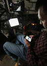 Nick Guetterman looks over the data shared by the crop sprayer he is seated in and cell phone while on his farm near Bucyrus, Kan., Wednesday, Feb. 19, 2014. Farmers from across the nation gathered in Washington this month for their annual trek to seek action on the most important matters in American agriculture. But this time, a new issue emerged: growing unease about how the largest seed companies are gathering vast amount of data from sensors on tractors, combines and other farm equipment. The sensors measure soil conditions, seeding rates, crop yields and many other variables. (AP Photo/Orlin Wagner)