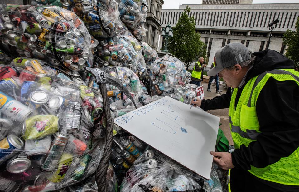 Peter Baker, owner of Can Bottle Return in Buffalo, writes a sign on top of bottles and cans that are not presently eligible for deposit redemption outside the New York State Capitol May 6, 2024. Baker joined dozens of bottle collectors and others from the redemption industry to call for the passage of bills that would modernize the New York State Bottle Bill. Among the changes in the law that bottle collectors, owners of redemption centers, and environmental groups want to see is the deposit fee raised to 10 cents from the present five cents per bottle. They also want to see an increase in the number of containers that are eligible for deposit.