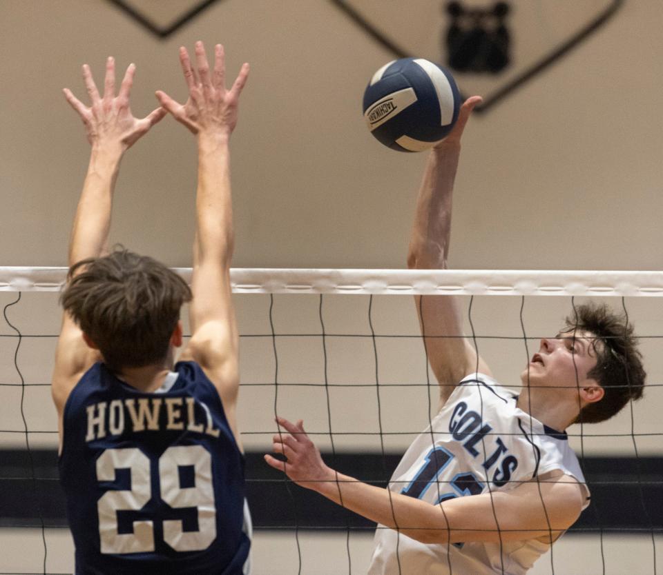 CBA Andrew Sasso hits a return as Howell Brent Romano tried to block it. Christian Brothers Academy Volleyball edge out Howell in Howell, NJ on April 7, 2022.