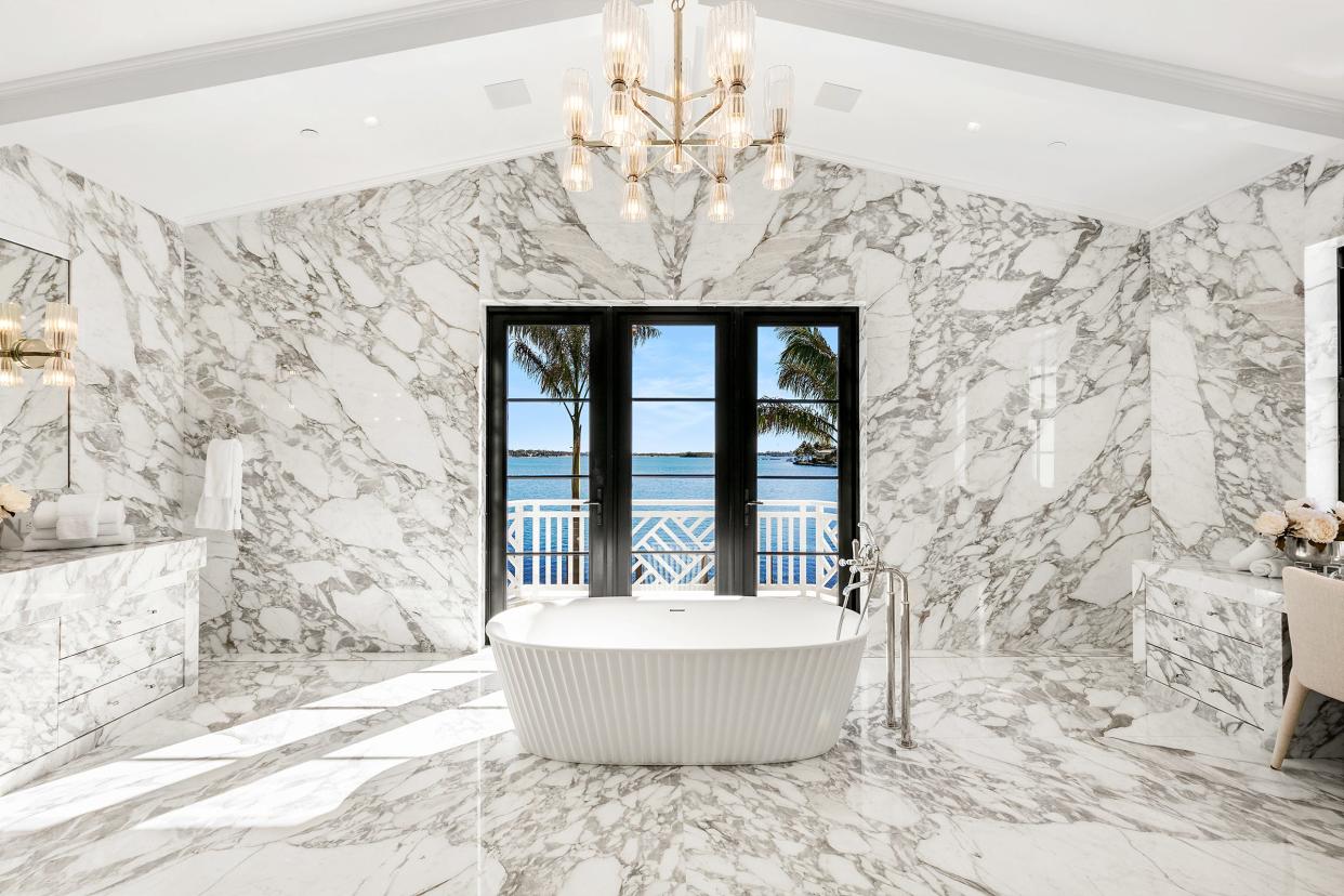 Walls in one of the two primary bathrooms at 10 Tarpon Island are covered in book-matched marble.