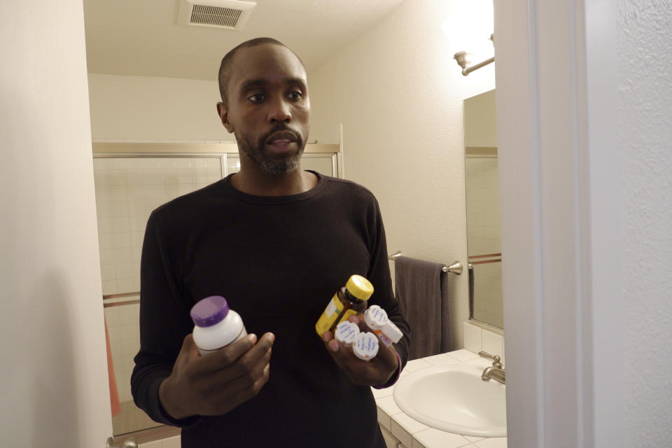 Anthony Jones takes his daily lupus medication and supplements at his Seattle apartment on June 20, 2023. Diagnosed with the disease when he was 19, Jones sometimes has difficulty making it to work when his lupus flares up. Washington lawmakers had cases like his in mind when they passed a new long-term care tax that takes effect July 1, making Washington the first state in the nation to deduct money from workers' paychecks to finance long-term care benefits. (AP Photo/Ed Komenda)