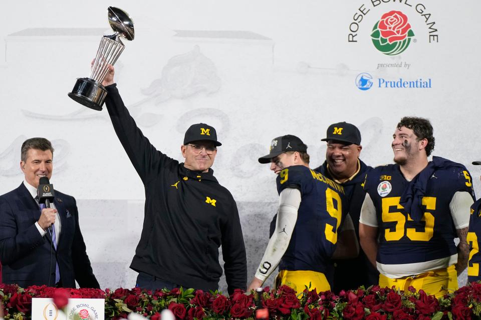 Michigan head coach Jim Harbaugh holds the winner's trophy after a win over Alabama in the Rose Bowl CFP NCAA semifinal college football game Monday, Jan. 1, 2024, in Pasadena, Calif. (AP Photo/Mark J. Terrill)