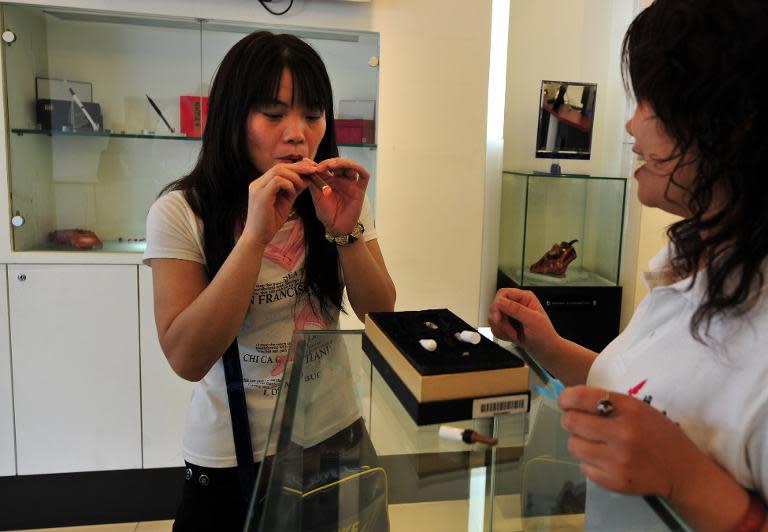 A customer is assisted by a salesperson at a shop selling electric smoking products in Beiijng in 2009 designed by Hon Lik