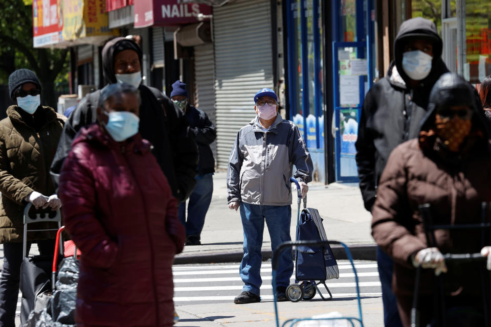 People wearing protective face masks wait in line at a free food distribution for people in need, outside the West Harlem Group Assistance in Manhattan, during the outbreak of the coronavirus disease (COVID-19) in New York city, New York, U.S., May 12, 2020. REUTERS/Mike Segar - RC25NG9N38MX