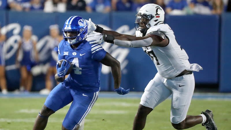 BYU running back Miles Davis runs past Cincinnati defensive end Eric Phillips (97) during game at LaVell Edwards Stadium in Provo on Friday, Sept. 29, 2023.