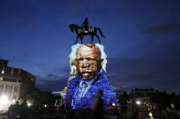 FILE - In this Wednesday, July 22, 2020 file photo, an image of the late Georgia Congressman and civil rights pioneer U.S. Rep. John Lewis is projected on to the pedestal of the statue of confederate Gen. Robert E. Lee on Monument Avenue in Richmond, Va. The statue has become a focal point for the Black Lives Matter protests in the area. (AP Photo/Steve Helber)